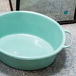 Przedmiot z tworzywa sztucznego w kolorze miętowym, używany w gospodarstwie domowym, idealny do gotowania i przechowywania żywności, produkowany przez AGD Lipiecki.